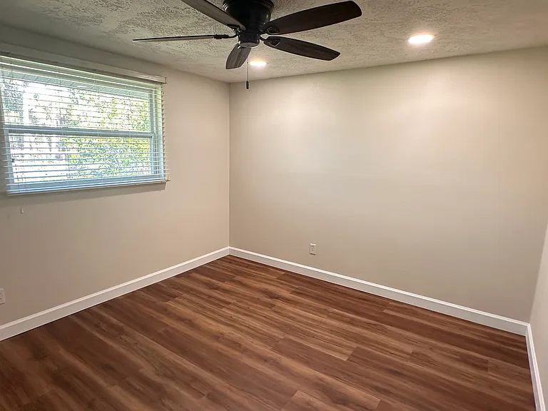 2nd bedroom overlooks mature empty lot featuring edible plants and fruit trees