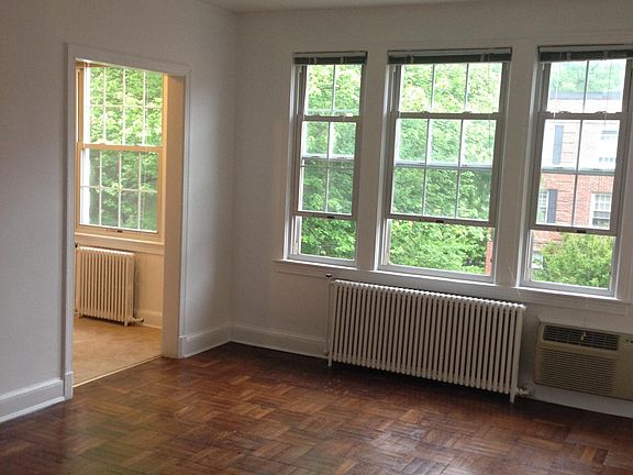 Living room with view to the kitchen. Gets great light and has a nice view of the front courtyard. Built-in air conditioner