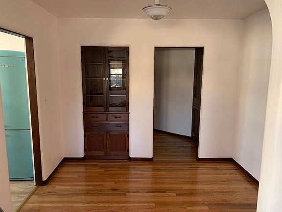 Looking into dining room with built in china cabinet and kitchen entrance from living room.