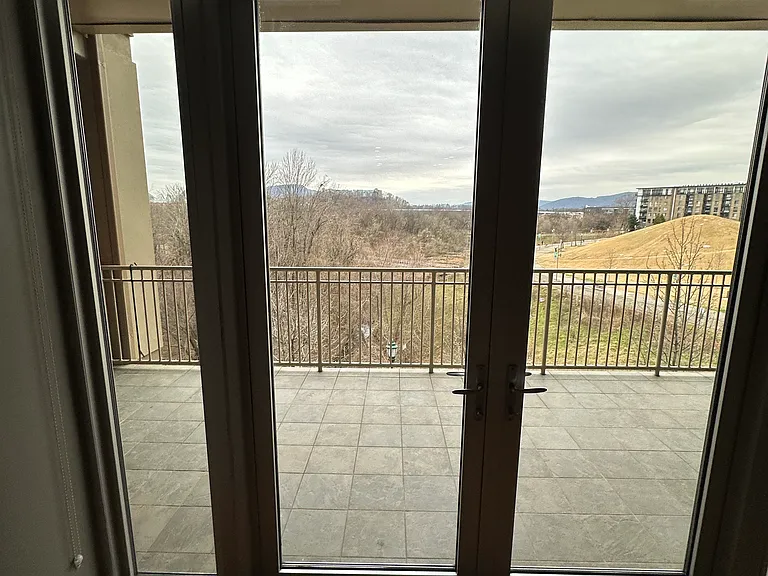 View of balcony and city/mountains from bedroom. Larger window/ balcony access and view from living room