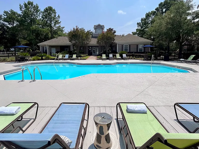 Dive into relaxation at the sparkling resort-style pool at Eagles Pointe Apartments. Surrounded by lush greenery and comfortable lounge chairs, it's the perfect spot to unwind or socialize.