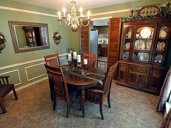 Formal Dining Rm has Shadow-Block Wainscot, Crown Moldings, lively Chandelier, and windows to the la