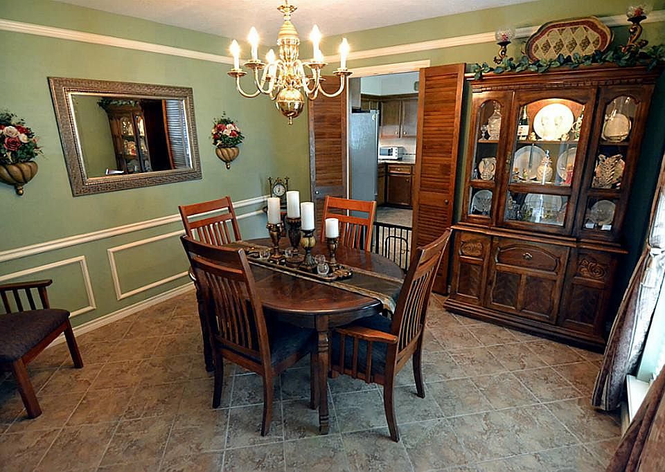 Formal Dining Rm has Shadow-Block Wainscot, Crown Moldings, lively Chandelier, and windows to the la