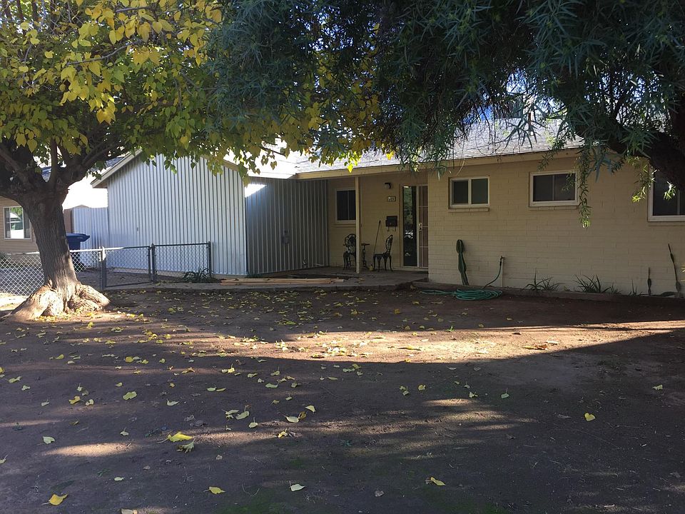 Shaded fenced front yard/driveway.