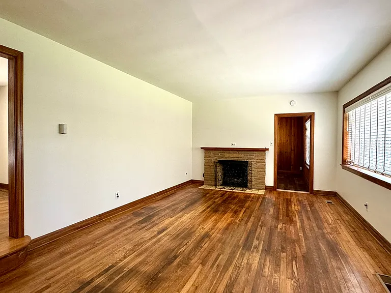 Living room. Step up into dining room to the left, remote-control gas fireplace next to entry into Den.
