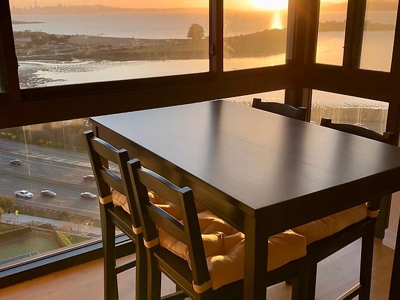 Dining area with floor to ceiling window. Dine in front of a beautiful sunset view of the Bay and the famous Golden Gate bridge.