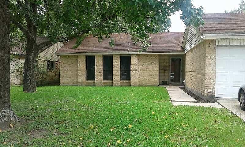 Trees and a large driveway greet you home.