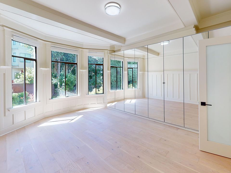 Sunlit room with a large window and wood-like flooring