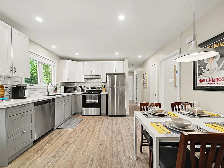Fully equipped modern kitchen featuring stainless appliances and ample counter space.