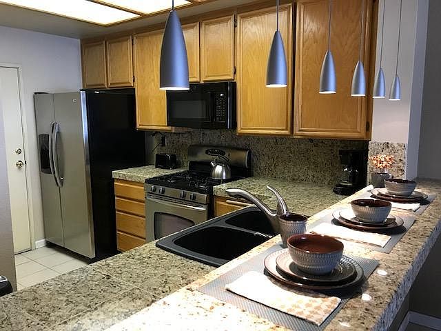 Large granite kitchen with new appliances, breakfast bar