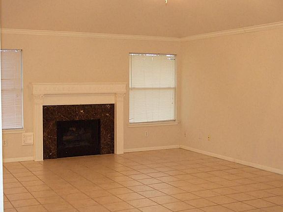Gas fireplace, crown molding and tile throughout (carpet in bedroom).