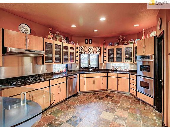 Amazing kitchen with granite counters, slate tile floor, S/S appliances that include a gas cooktop, professional hood, double oven & a built-in refrigerator. Large walk-in pantry as well.