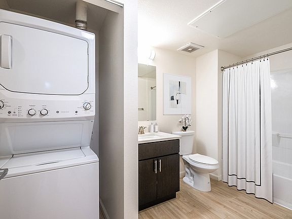 Closet with washer and dryer next to bathroom.