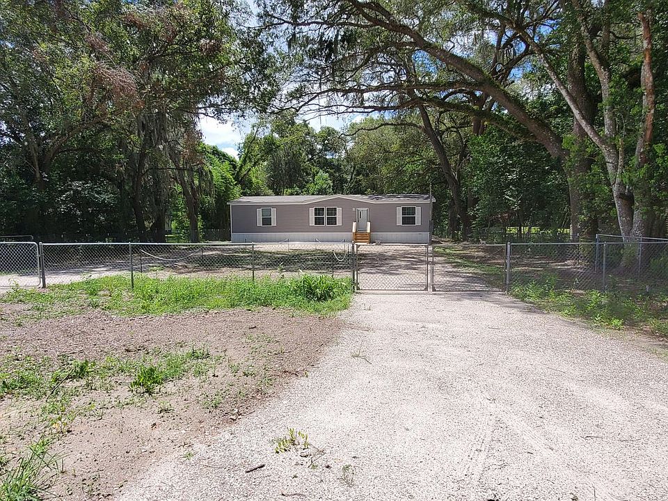 Fenced front yard with U-shaped drive way.