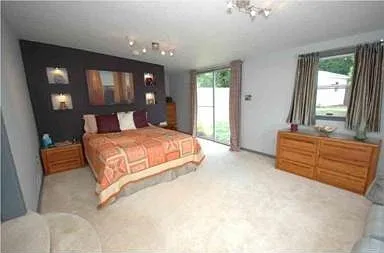 Primary bedroom with lighted alcoves, direct access to backyard.