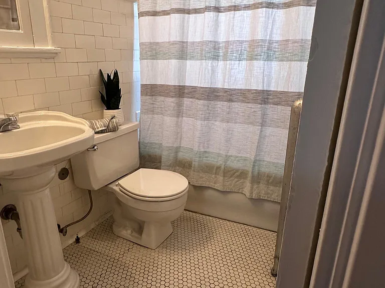 Bathroom with original porcelain subway tile and ceramic floors