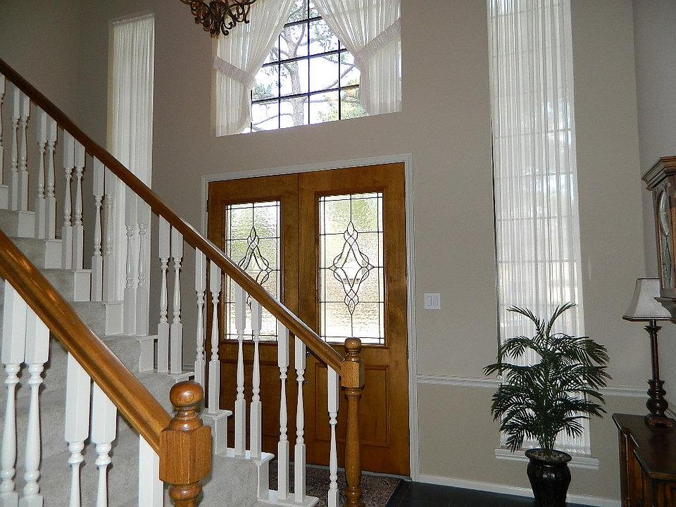 The entry features double doors with leaded glass inserts and large surrounding windows that keep the entry light and bright.