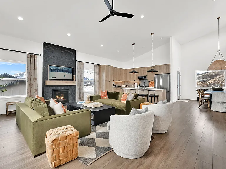 Living room with Smart TV and gas fireplace, kitchen with new appliances, and dining room table.