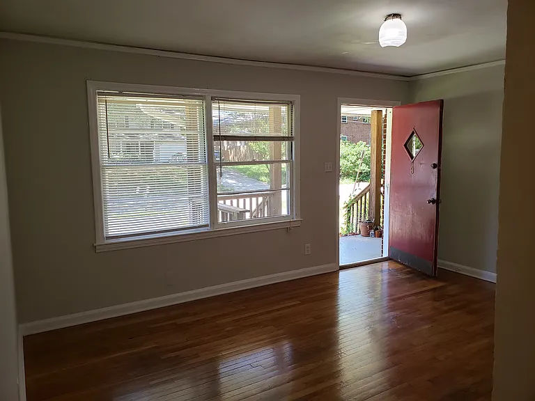 living room showing entrance to apartment.. beautiful hardwood floors