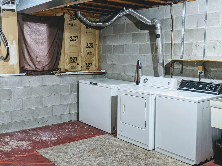 Downstairs large unfinished laundry/utility room with deep freezer