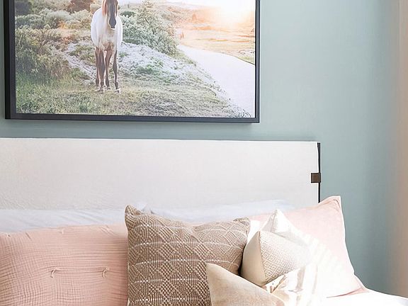 Spacious bedroom with tall ceilings and light green accent wall