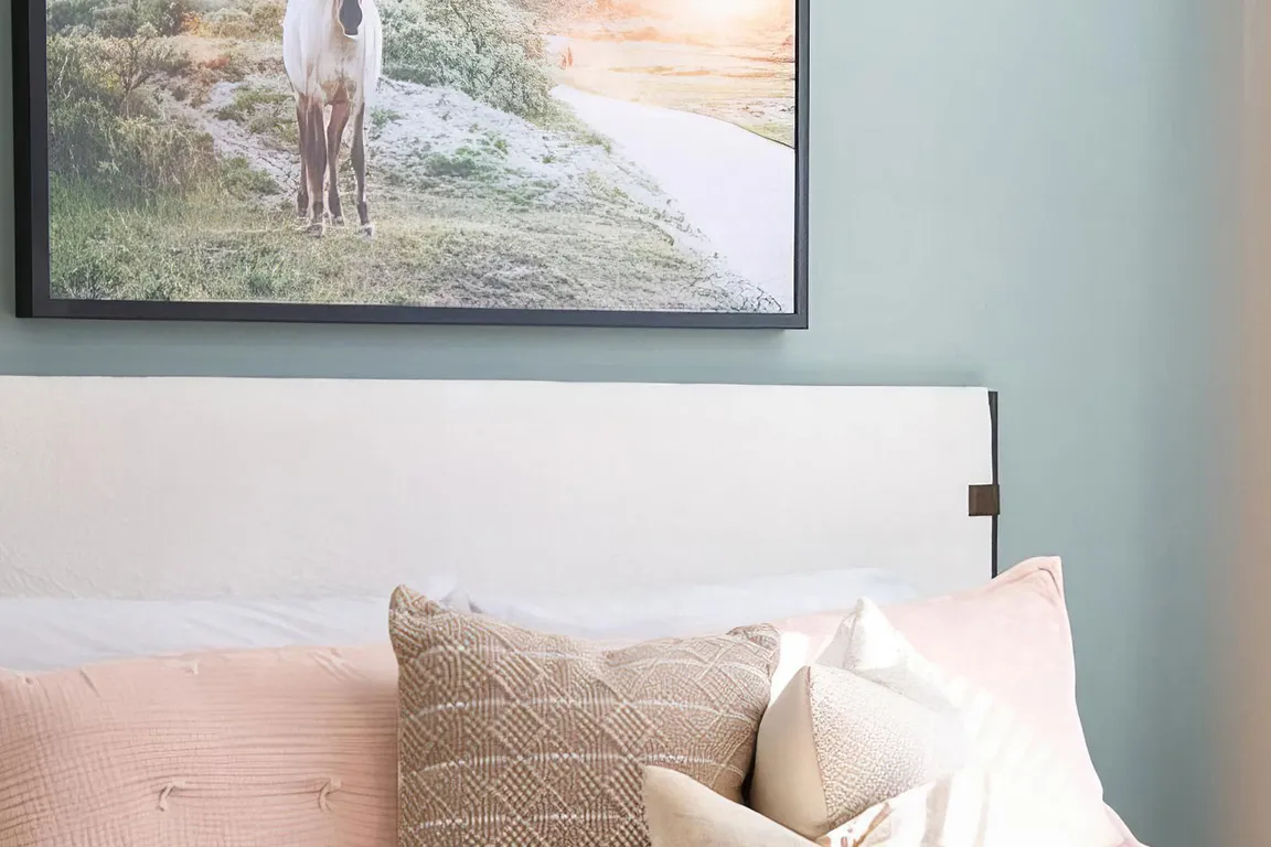 Spacious bedroom with tall ceilings and light green accent wall