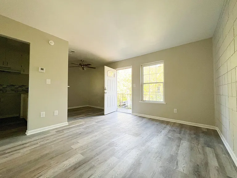 This charming apartment features a well-lit living area with newly painted walls and luxury vinyl plank flooring throughout.