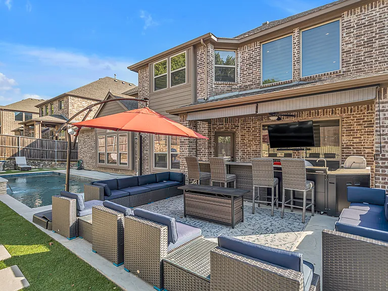 Gorgeous Backyard Furnished Firepit Area with Outdoor Kitchen and Mounted Flatscreen