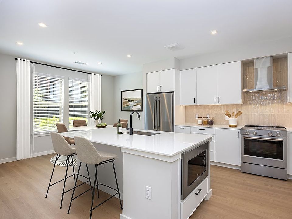 Upgrade Collection 3BR Townhome Kitchen with white cabinetry, white quartz countertops, and over-the-range hood