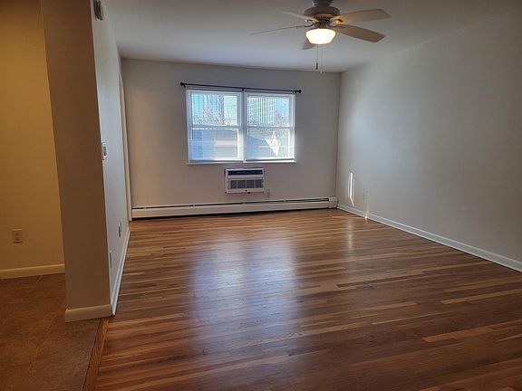 Large living room / sleeping area with gleaming hard wood floors