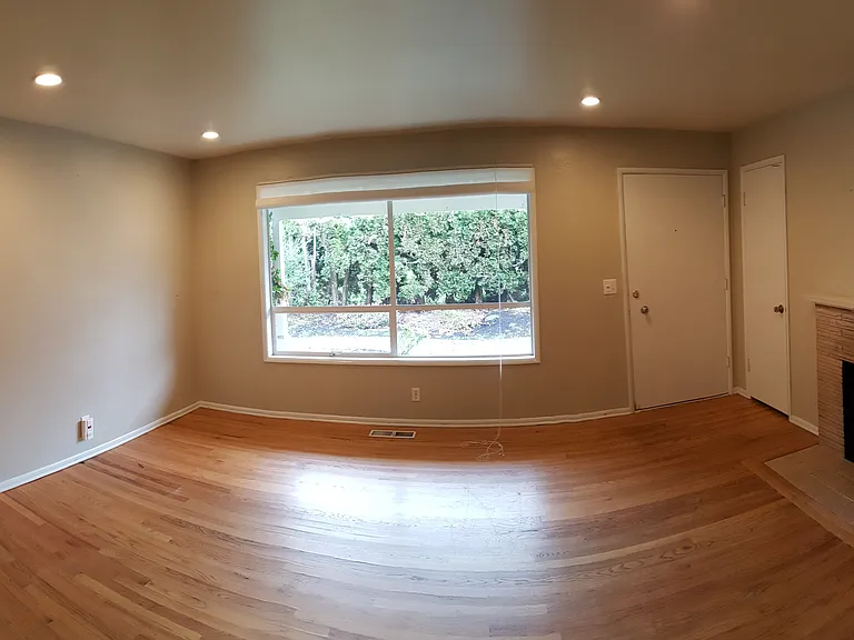 The front entry and living room has covered porch out front, an entry closet for coats, real hardwood floors, and a wood burning fireplace