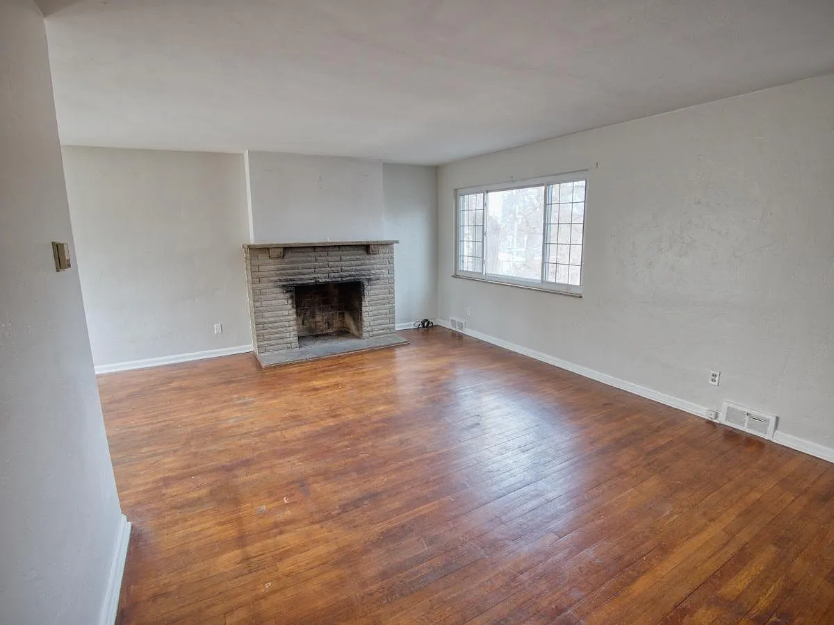 Bright and light spacious Living room, with hard wood floors, and a beautiful decorative Fire Place. - 1664 Bellaire Pl