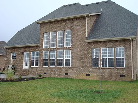 Rear of home showing floor to ceiling windows in the great room.