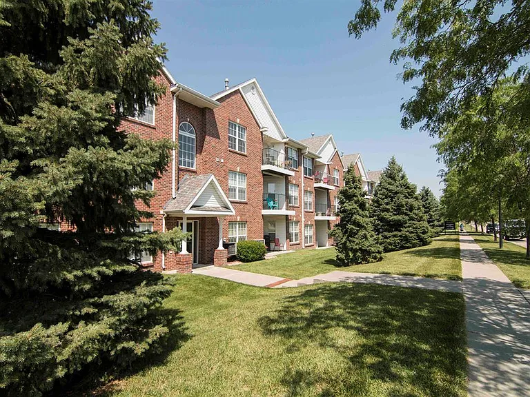 Our community features charming brick exteriors surrounded by lush greenery and inviting walkways.