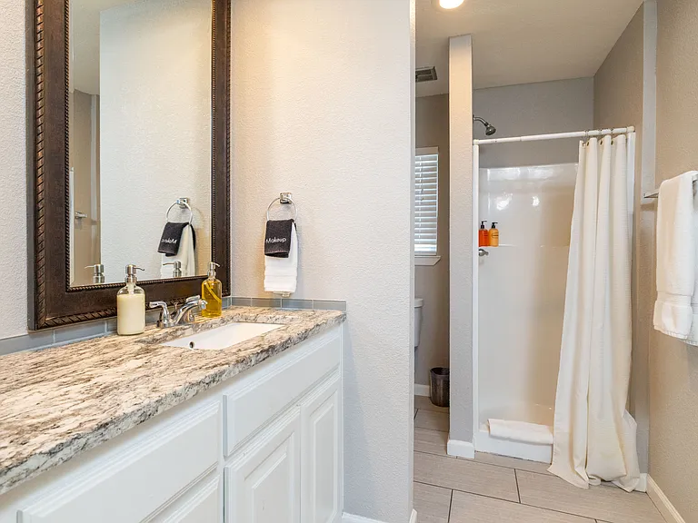 Bathroom 2 with walk-in shower and sink.