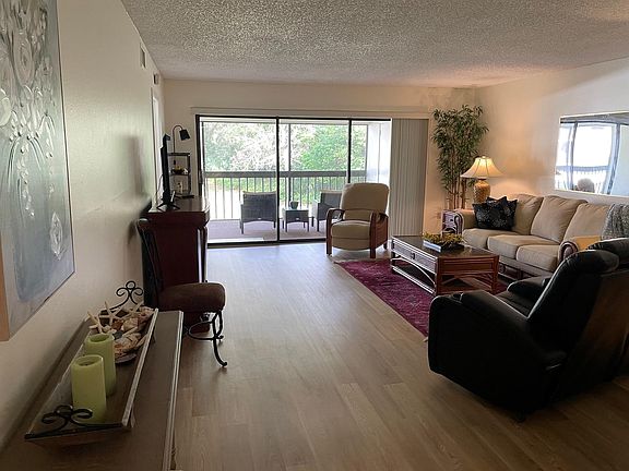 Great room with dining and living area, electric fireplace, sliders to lanai