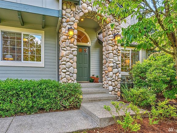 Welcoming covered front porch, with beautiful river rock stones.