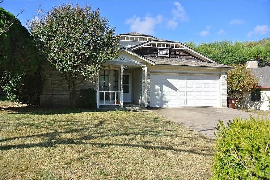 Front yard and garage. House has a two car garage with automatic garage door opener