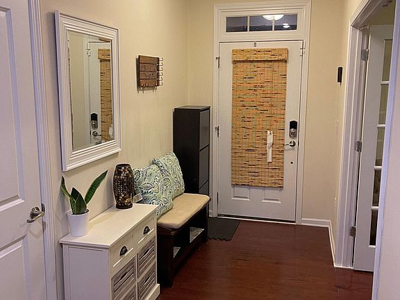 Foyer with a coat closet that continues under the stairs with plenty of storage.