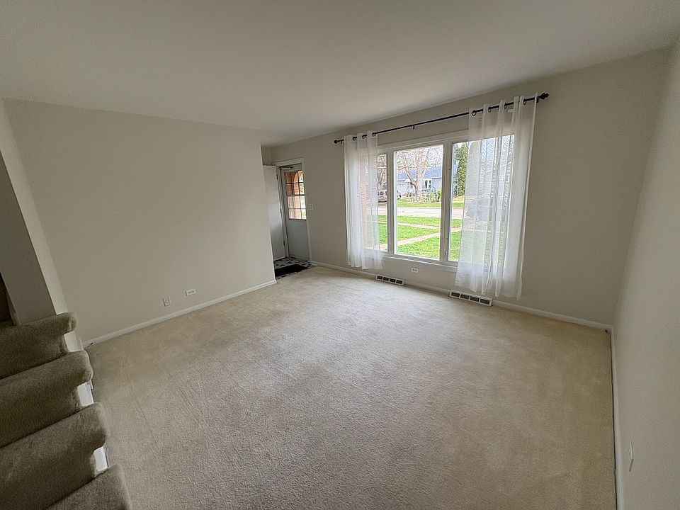 1st floor living room, view of front door and windows from bottom of stairs.