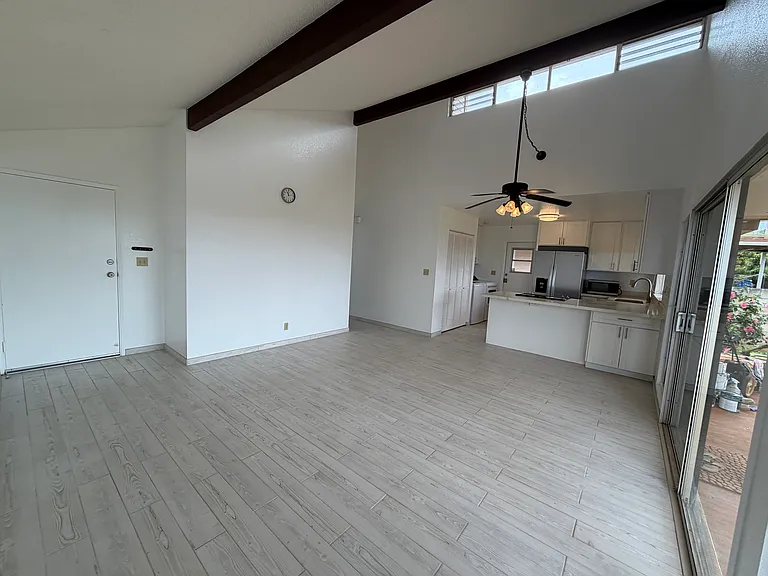 Living room view 4. Vaulted ceiling, open kitchen, new refrigerator, freshly painted, bright and airy.
