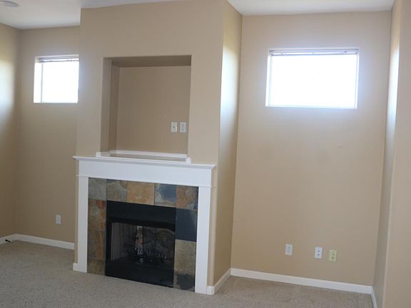 Living room gas fireplace and the windows show the great natural light.