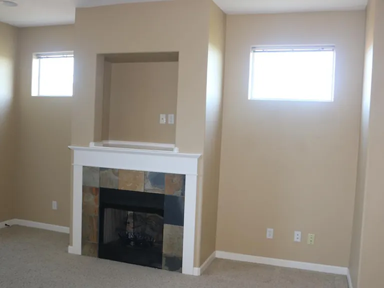 Living room gas fireplace and the windows show the great natural light.