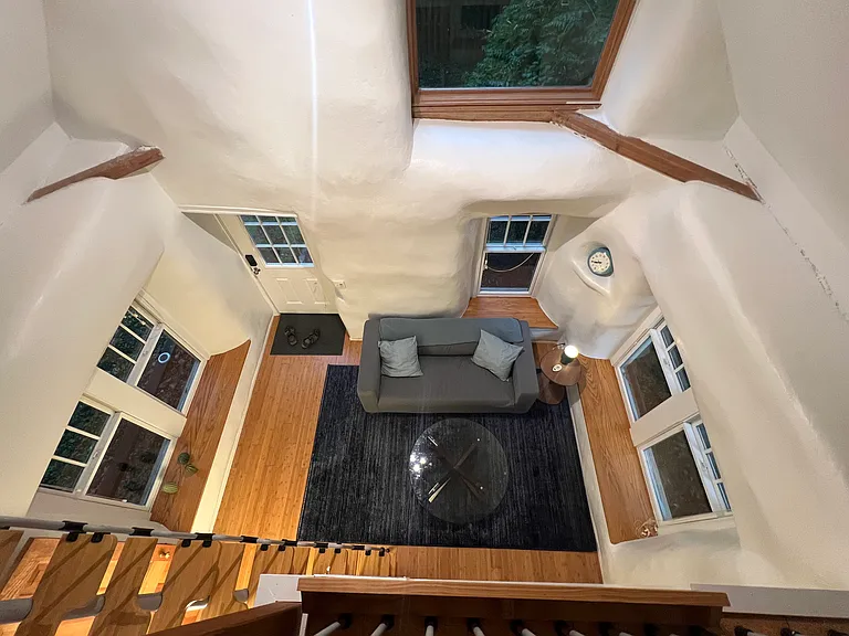 Loft view showing the cottage's open layout, large living area, oversized windows and dedicated lounging space.