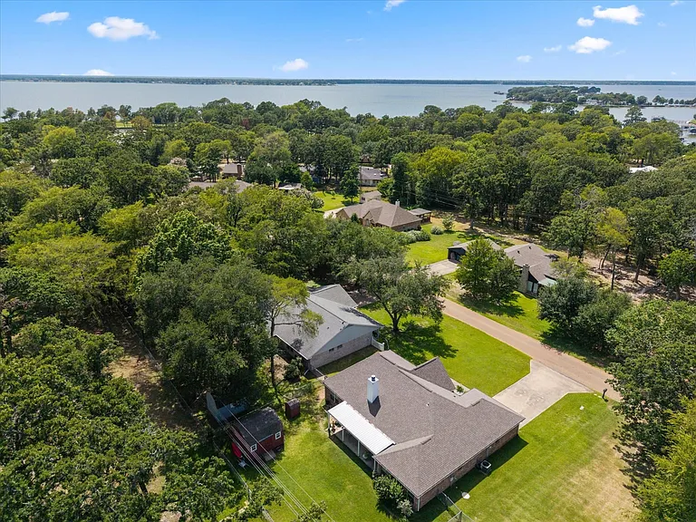 Aerial property showcasing a shingle roof and a concrete
 driveway