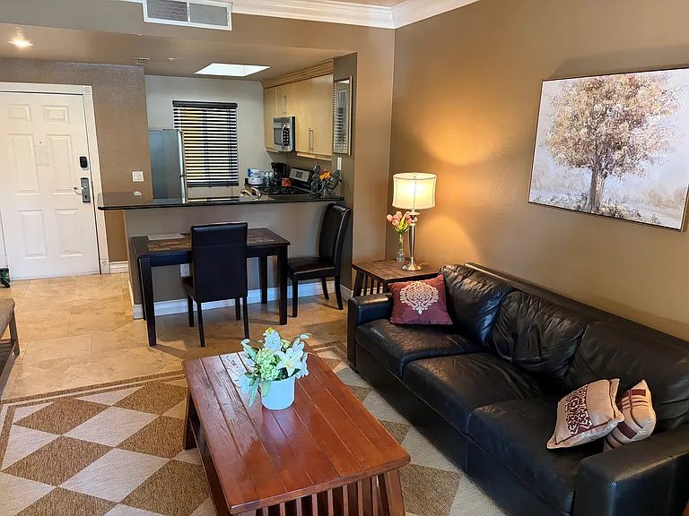 Bright and spacious open-concept living area featuring a comfortable living room, dining space, and fully equipped kitchen, all designed to make extended stays feel like home!