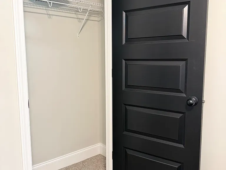 Dedicated closet storage with a hanging rod and wire shelf, offering convenient space.