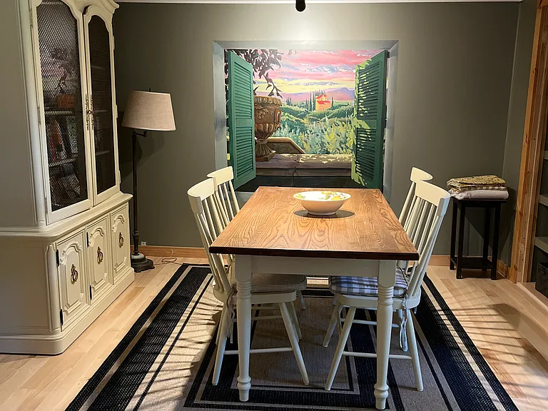 Dining area with mural by artist Russell Whitten who takes a group each year to Italy to teach painting. This mural depicts the view from their location.