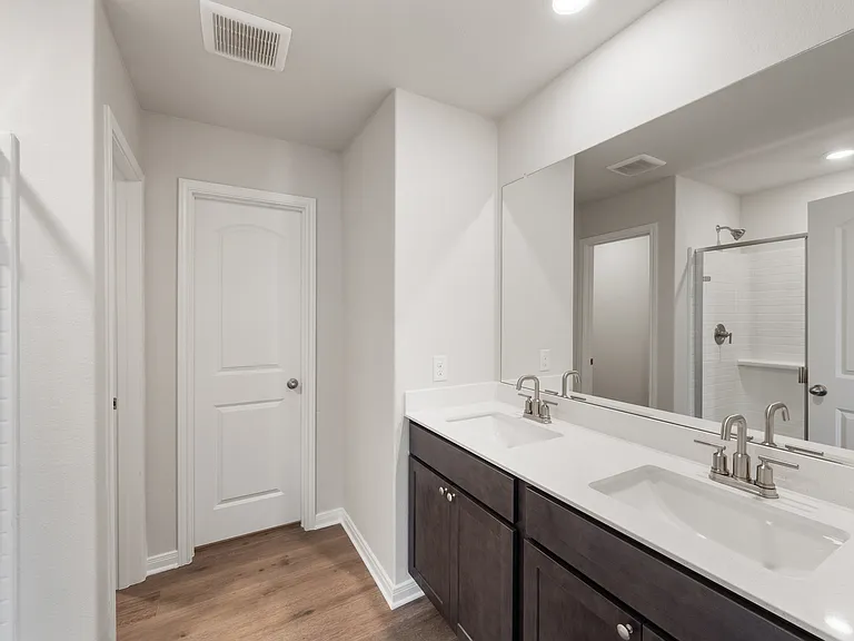 The master bathroom has a large dual-sink vanity.
