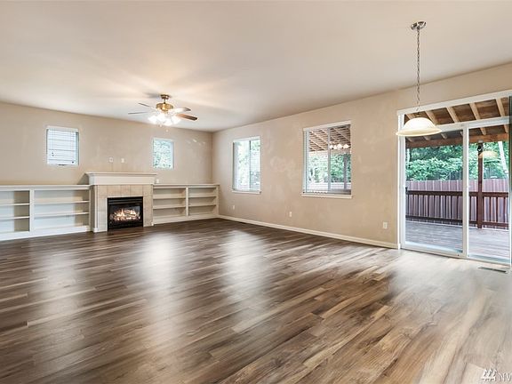HUGE open concept living room with cozy gas fireplace and custom built-in shelving.
